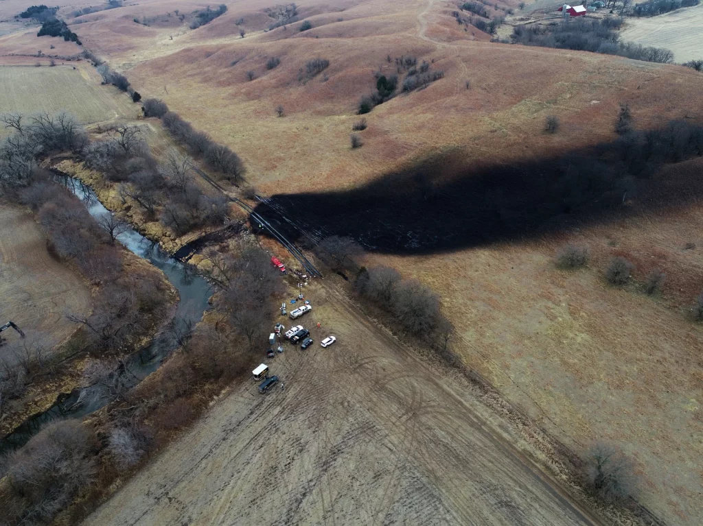 Aerial view of the keystone oil spill. Shows large black stain on the land and in the nearby creek. 