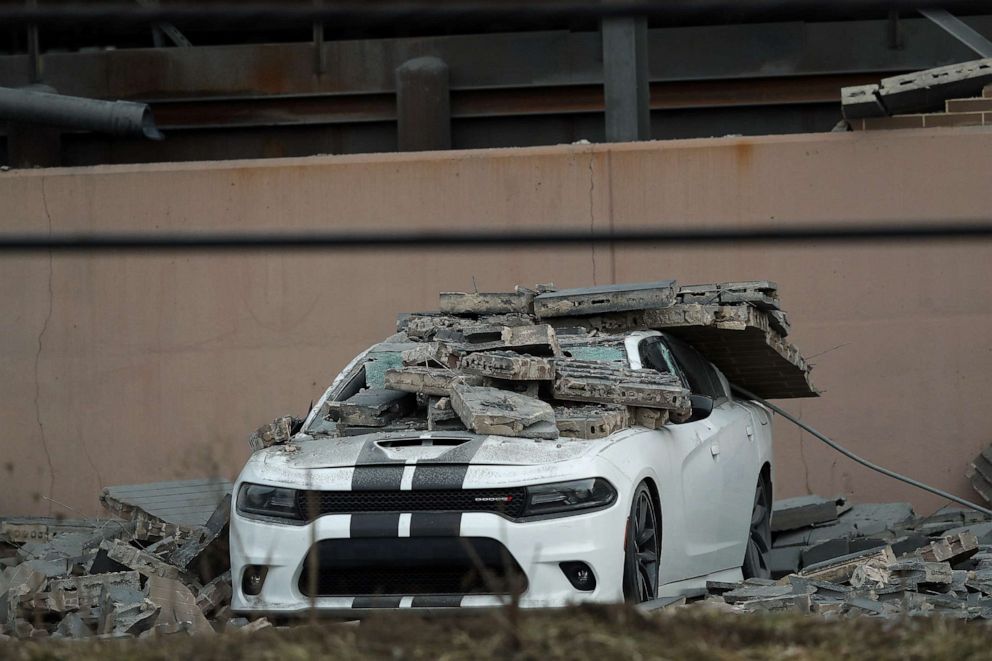 images of a white dodge charger with concrete blocks on the top of the car
